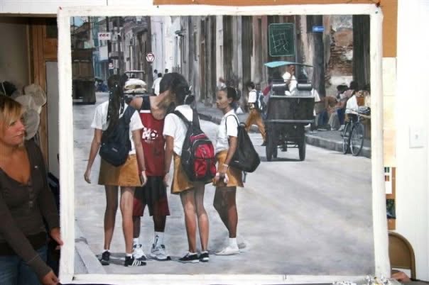 Framed photograph of four people standing together on a narrow city street, with buildings and a cart behind them.